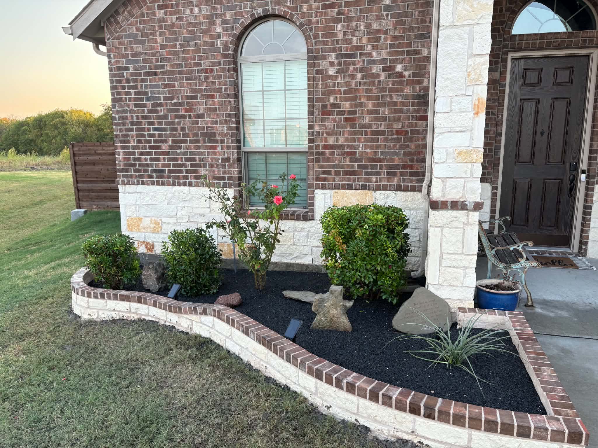 Flower bed after shrub trimming, planting and decorative gravel installation